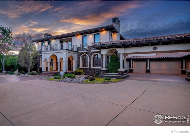 mediterranean / spanish-style house with a balcony and a garage