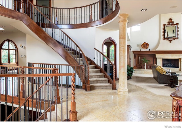 stairs with a high ceiling and decorative columns