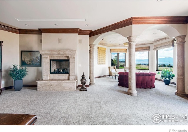 living room featuring carpet flooring, plenty of natural light, and ornate columns