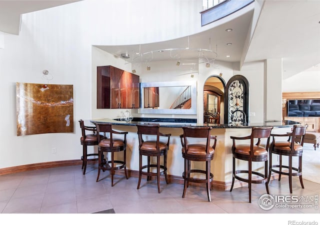 kitchen featuring a kitchen breakfast bar, kitchen peninsula, and light tile patterned floors