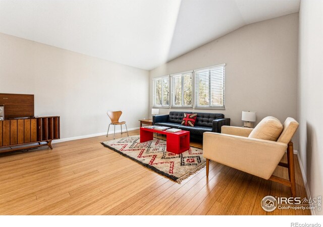 living room with hardwood / wood-style flooring and vaulted ceiling