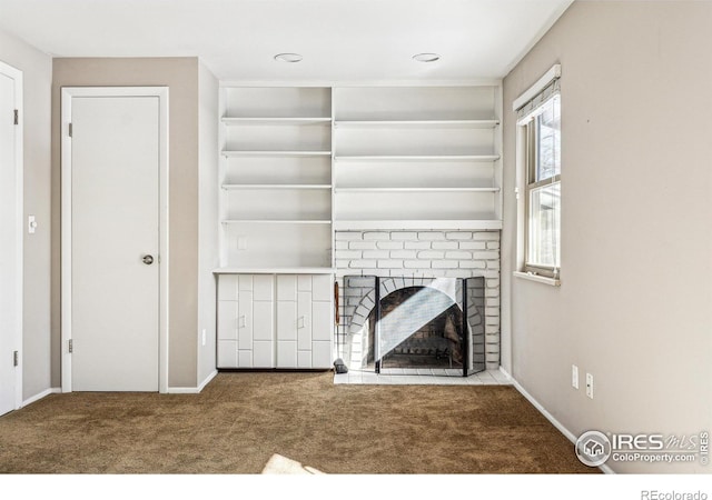 unfurnished living room with carpet and a fireplace