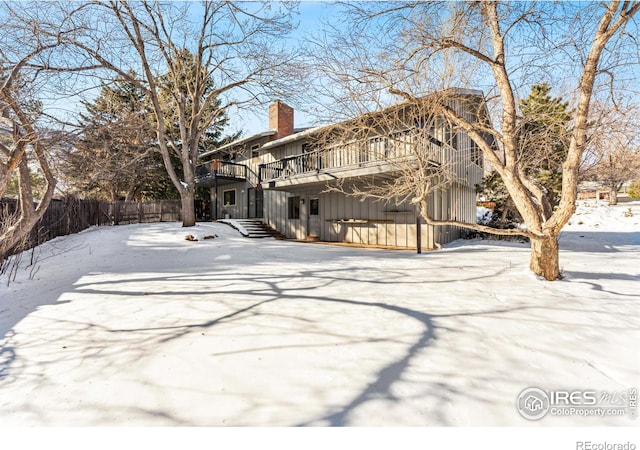 snow covered rear of property featuring a deck