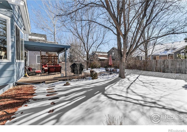 yard covered in snow featuring a deck