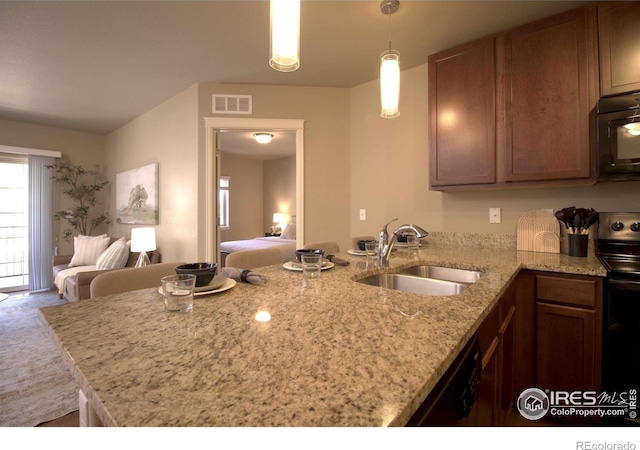 kitchen with pendant lighting, sink, black appliances, and kitchen peninsula