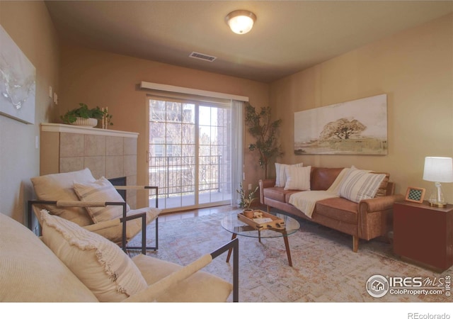 living room featuring a tiled fireplace