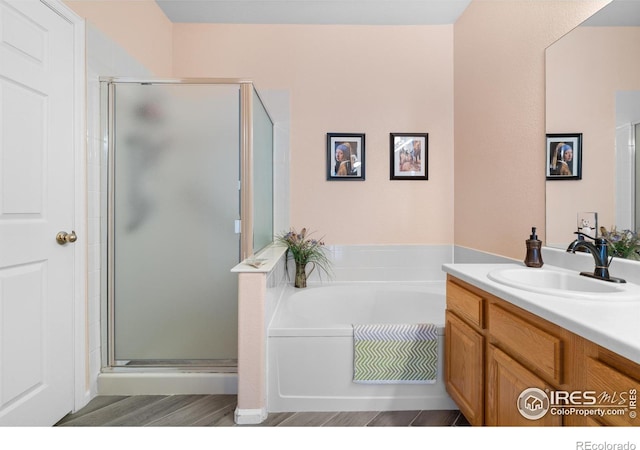 bathroom featuring independent shower and bath, vanity, and wood-type flooring