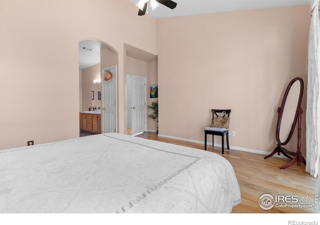 bedroom with connected bathroom, sink, ceiling fan, and light wood-type flooring