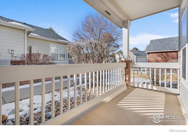 snow covered back of property featuring central AC unit