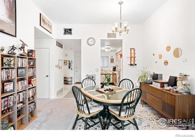 dining room featuring light colored carpet and an inviting chandelier