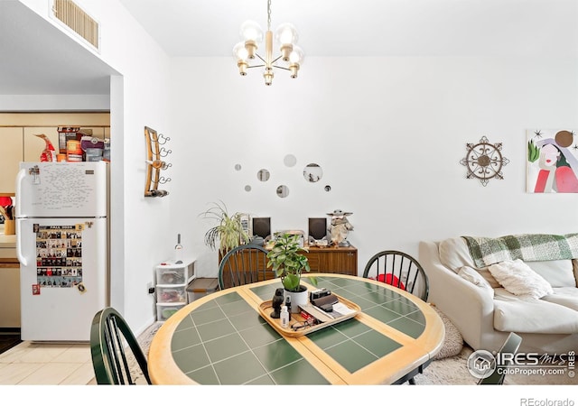 tiled dining space with a chandelier