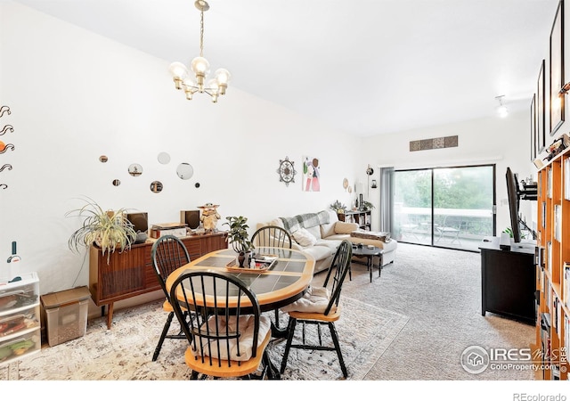 dining area with light carpet and a notable chandelier