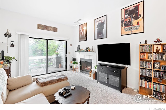 carpeted living room with track lighting and a tile fireplace