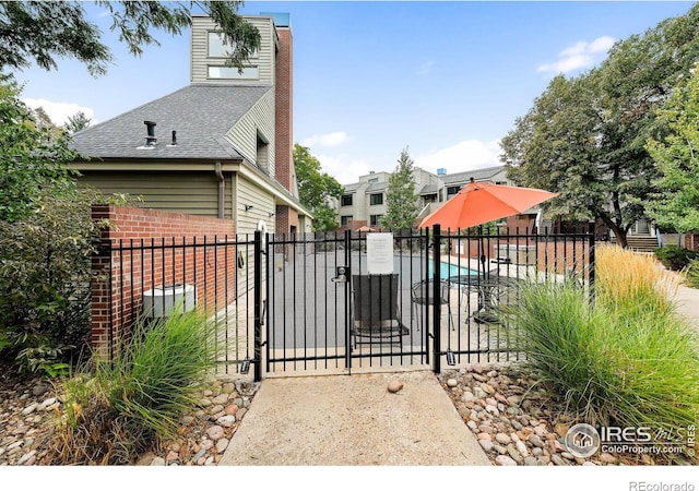 view of gate featuring a community pool