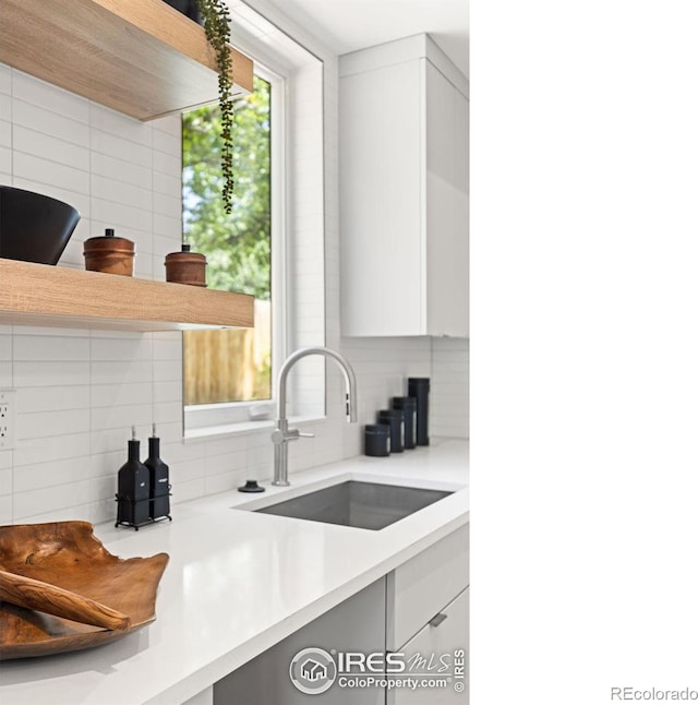 kitchen with sink, decorative backsplash, and white cabinets