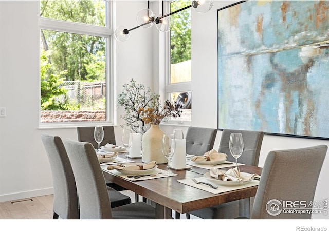 dining room featuring a chandelier, light hardwood / wood-style flooring, and a wealth of natural light