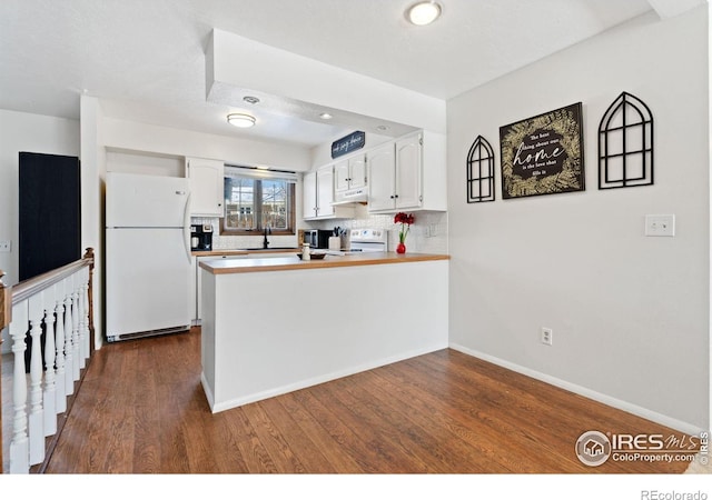 kitchen featuring white appliances, white cabinetry, tasteful backsplash, dark hardwood / wood-style flooring, and kitchen peninsula