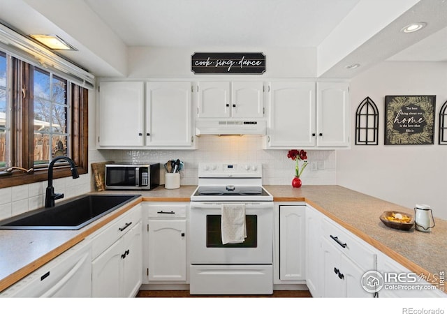 kitchen with tasteful backsplash, sink, white appliances, and white cabinets