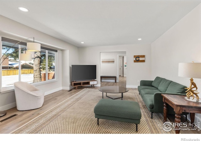 living area featuring light wood-style flooring, visible vents, baseboards, and recessed lighting