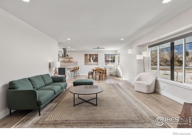 living room featuring light wood-style floors, baseboards, and recessed lighting