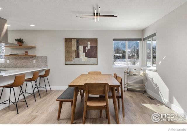 dining area featuring light wood finished floors, visible vents, baseboards, and recessed lighting