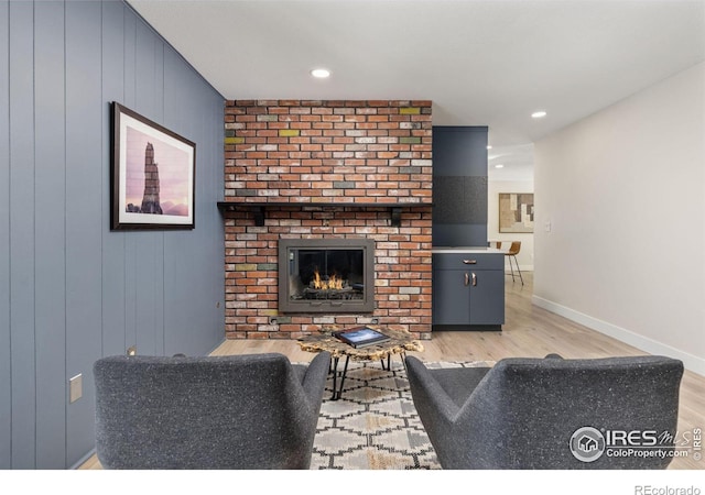 living room with light wood finished floors, a fireplace, baseboards, and recessed lighting