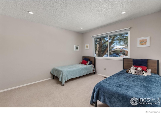 bedroom with a textured ceiling, carpet floors, recessed lighting, and baseboards