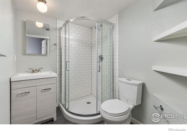 full bathroom with toilet, a shower stall, and vanity