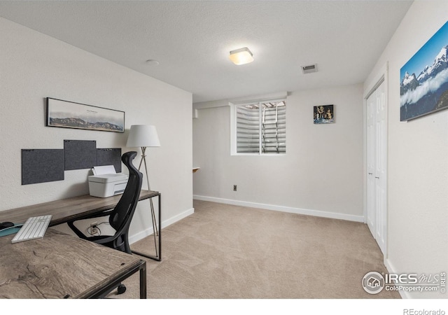 home office featuring visible vents, light carpet, baseboards, and a textured ceiling