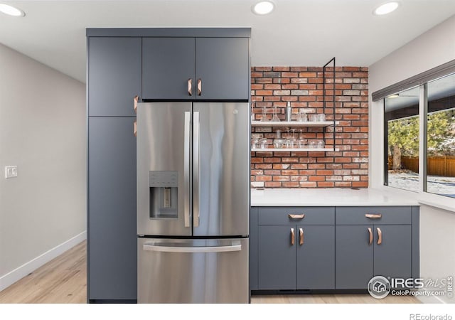 kitchen with light wood-style floors, recessed lighting, light countertops, and stainless steel fridge with ice dispenser