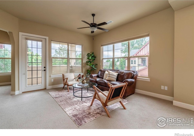 carpeted living room with ceiling fan