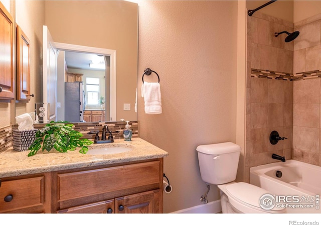 full bathroom featuring vanity, toilet, and tiled shower / bath combo