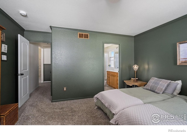 carpeted bedroom with crown molding and ensuite bathroom