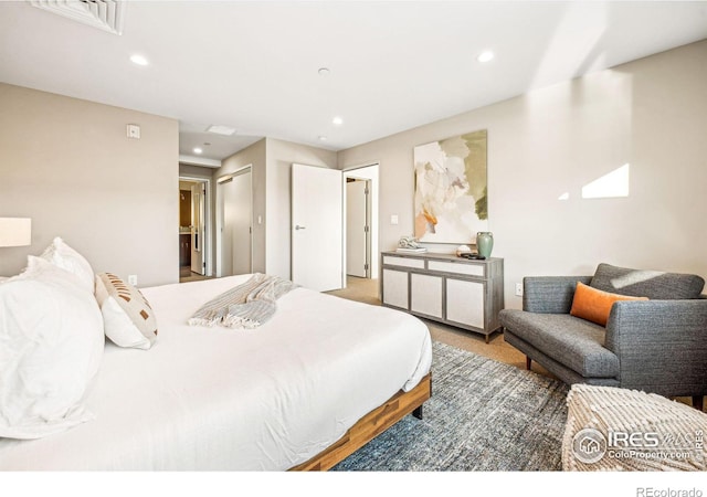 bedroom featuring connected bathroom and carpet flooring