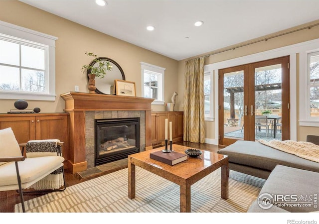 living room featuring light wood-type flooring, a fireplace, and french doors