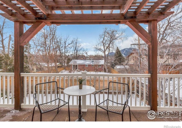 snow covered patio featuring a deck with mountain view