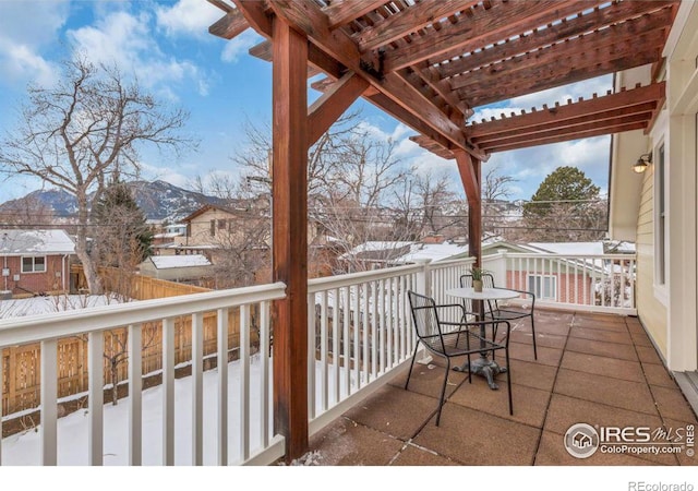 snow covered back of property featuring a pergola and a mountain view