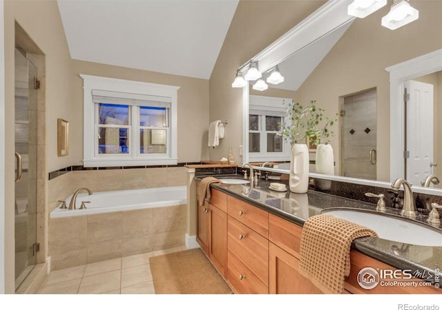 bathroom with lofted ceiling, vanity, tile patterned flooring, and plus walk in shower