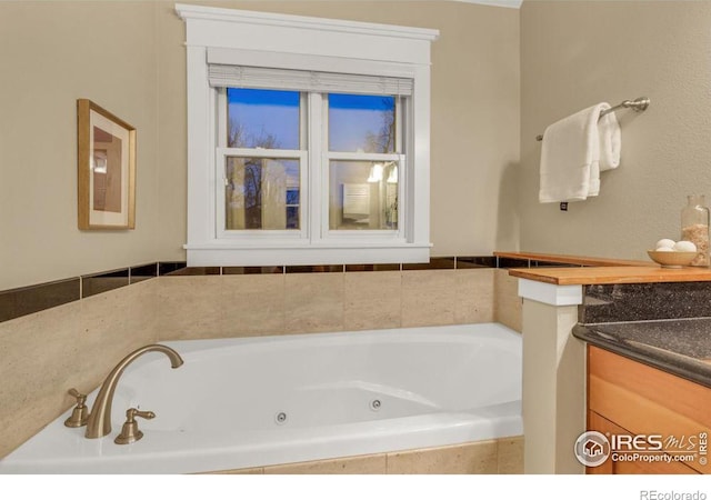 bathroom featuring vanity and tiled tub