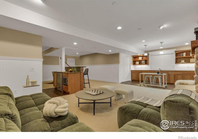 carpeted living room featuring bar area