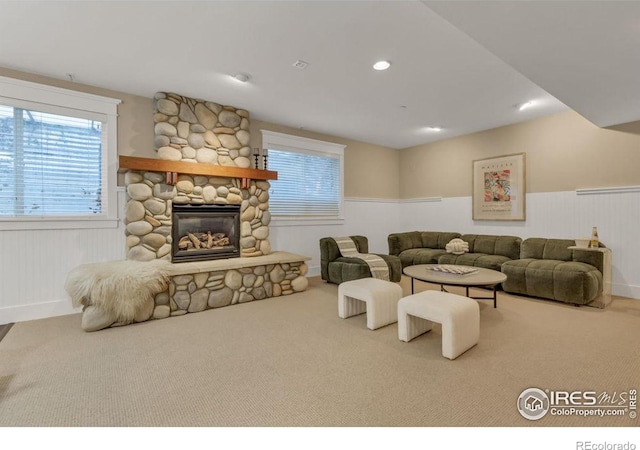 living room featuring a stone fireplace and carpet