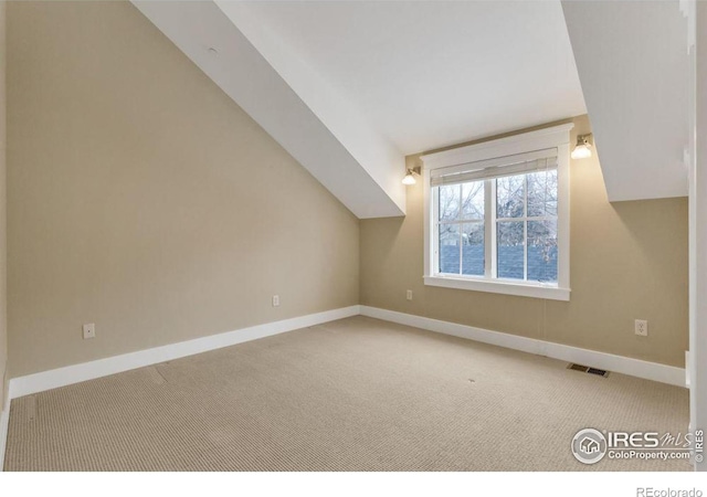 additional living space with vaulted ceiling and carpet