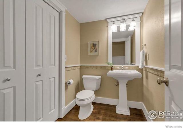 bathroom featuring wood-type flooring, sink, and toilet