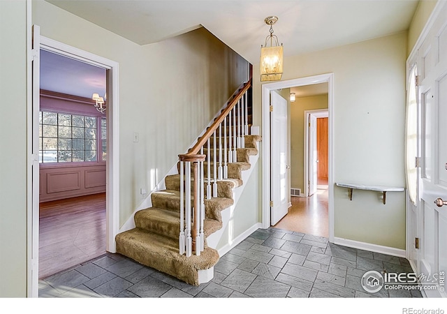 stairway featuring a chandelier