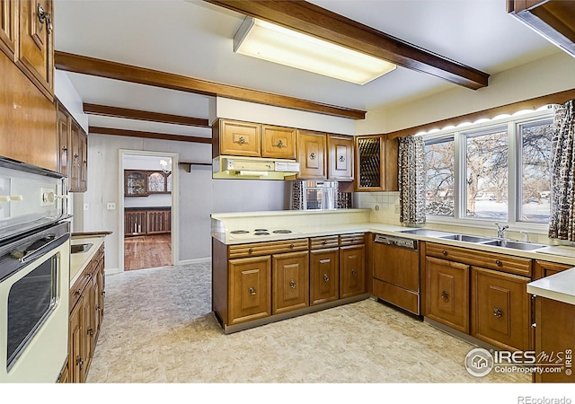 kitchen with dishwasher, sink, kitchen peninsula, white oven, and beam ceiling