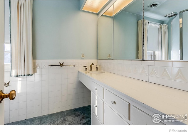 bathroom with tile walls and vanity