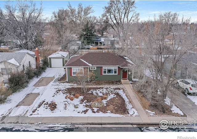 view of front of home with a garage and an outbuilding