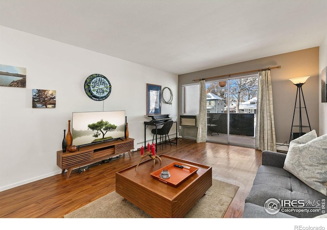 living room featuring a baseboard heating unit and wood-type flooring