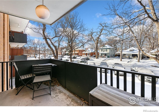 view of snow covered back of property