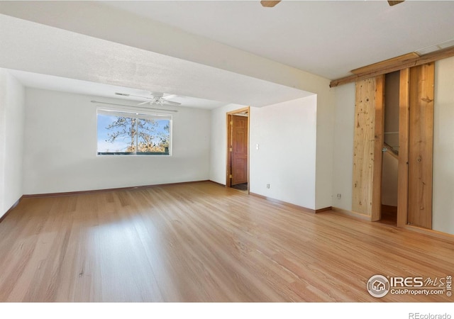 empty room with ceiling fan and light wood-type flooring